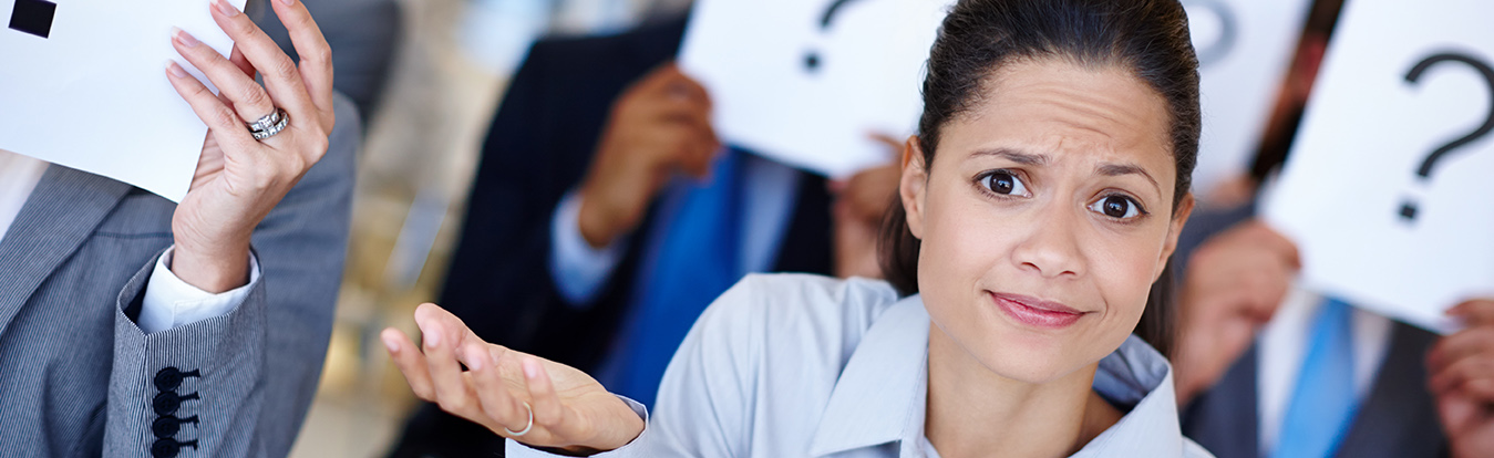 Puzzled woman in front a people holding question mark signs