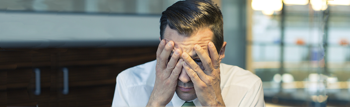 A stressed attorney with his head in hands