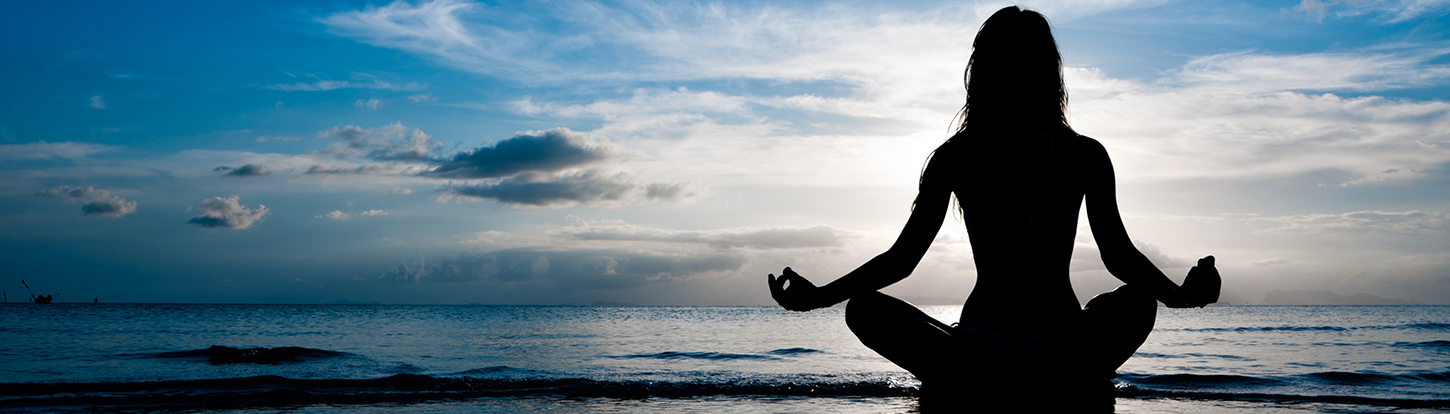 A woman meditating on a beach