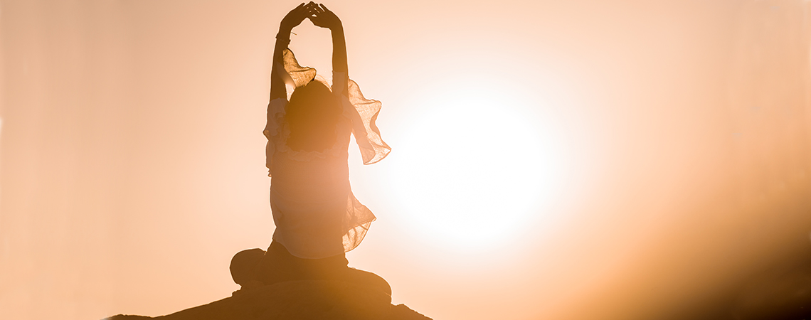 A woman stretching before a sunrise