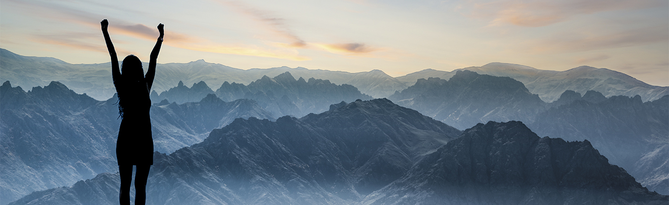 A woman at the top of a mountain