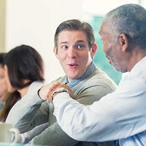 Younger lawyer fist bumps older lawyer.