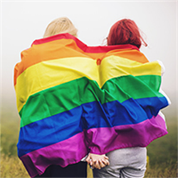 A couple draped in a rainbow flag