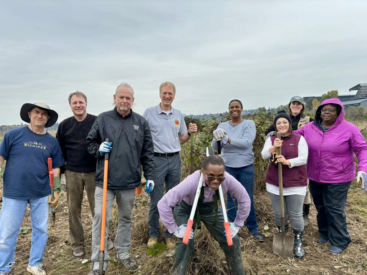 WSBA staff members and Board of Governors take a break from removing blackberry buses  at the University of Washington Horticulture Center.