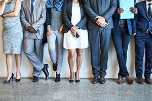 Job candidates lined up against a wall waiting for interview