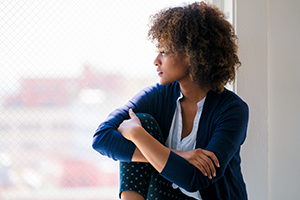 A woman looks contemplatively out a window