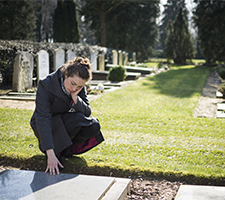 I woman mourning over a grave